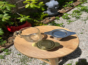 Wooden tray with glass and metal tea infusers on a garden path
