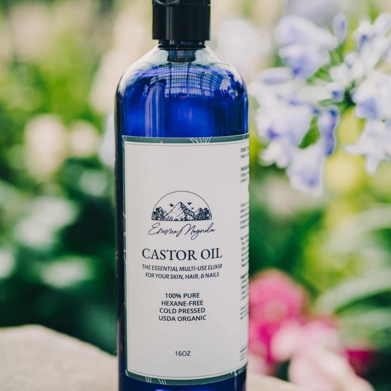 Blue bottle of castor oil with a label on a wooden surface with a blurred natural background