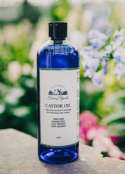 Blue bottle of castor oil with a label on a wooden surface with a blurred natural background