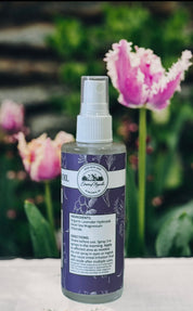 Bottle of organic lavender hydrosol with tulips in the background