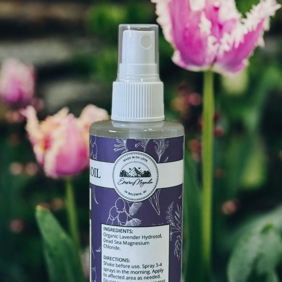 Bottle of organic lavender hydrosol with tulips in the background