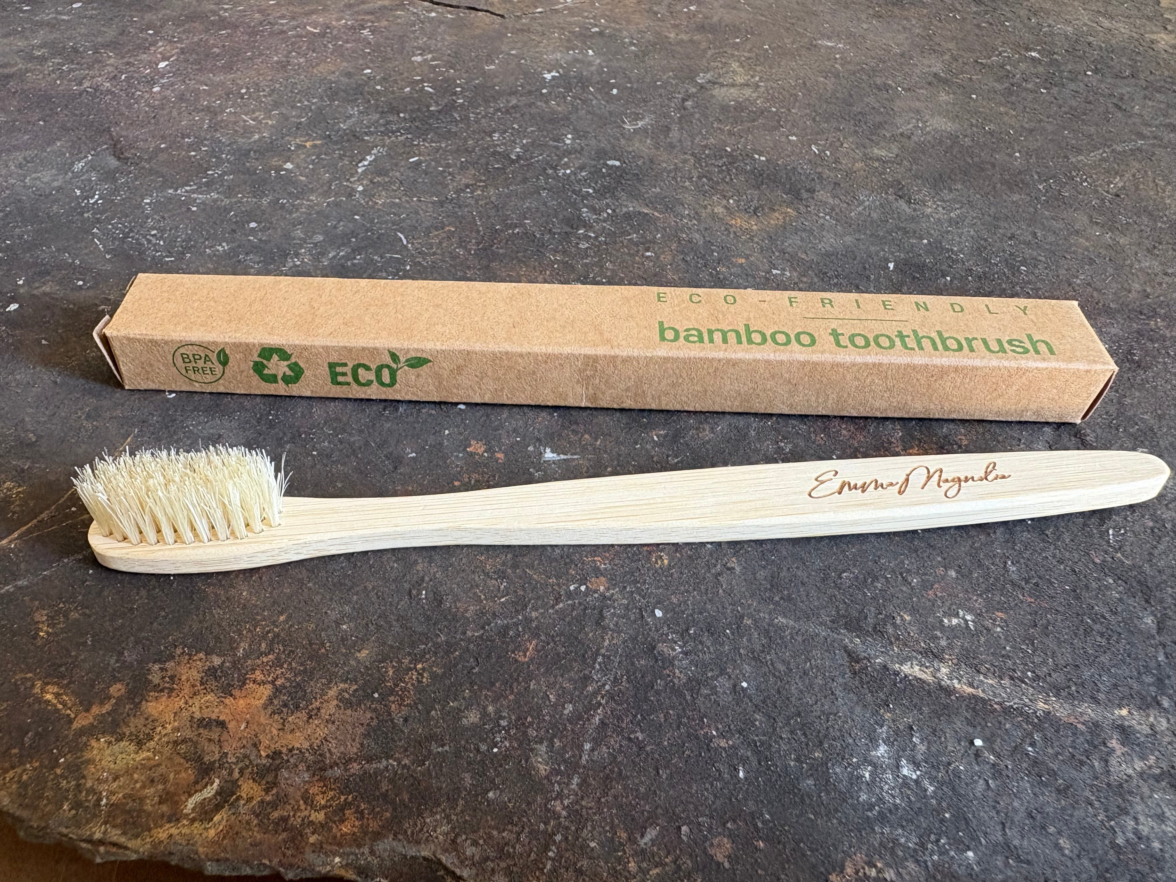 Bamboo toothbrush with 'Eco-Friendly' packaging on a dark surface