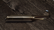 Metallic tool with textured surface on a wooden background