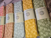 Set of patterned castor oil packs with labels on a textured surface