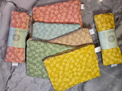 Set of patterned castor oil packs with visible branding on a gray surface